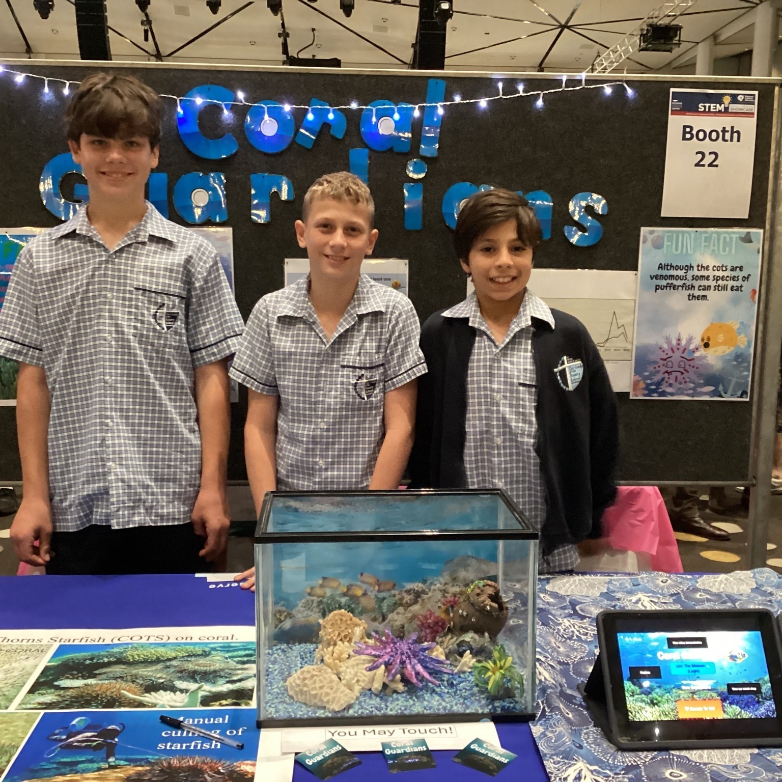 Students presenting a project at a school exhibition display.